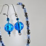 blue beaded drop earring with hook wire attachment and beaded necklace backdrop