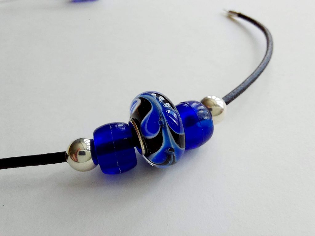 thread beads onto leather cord bracelet