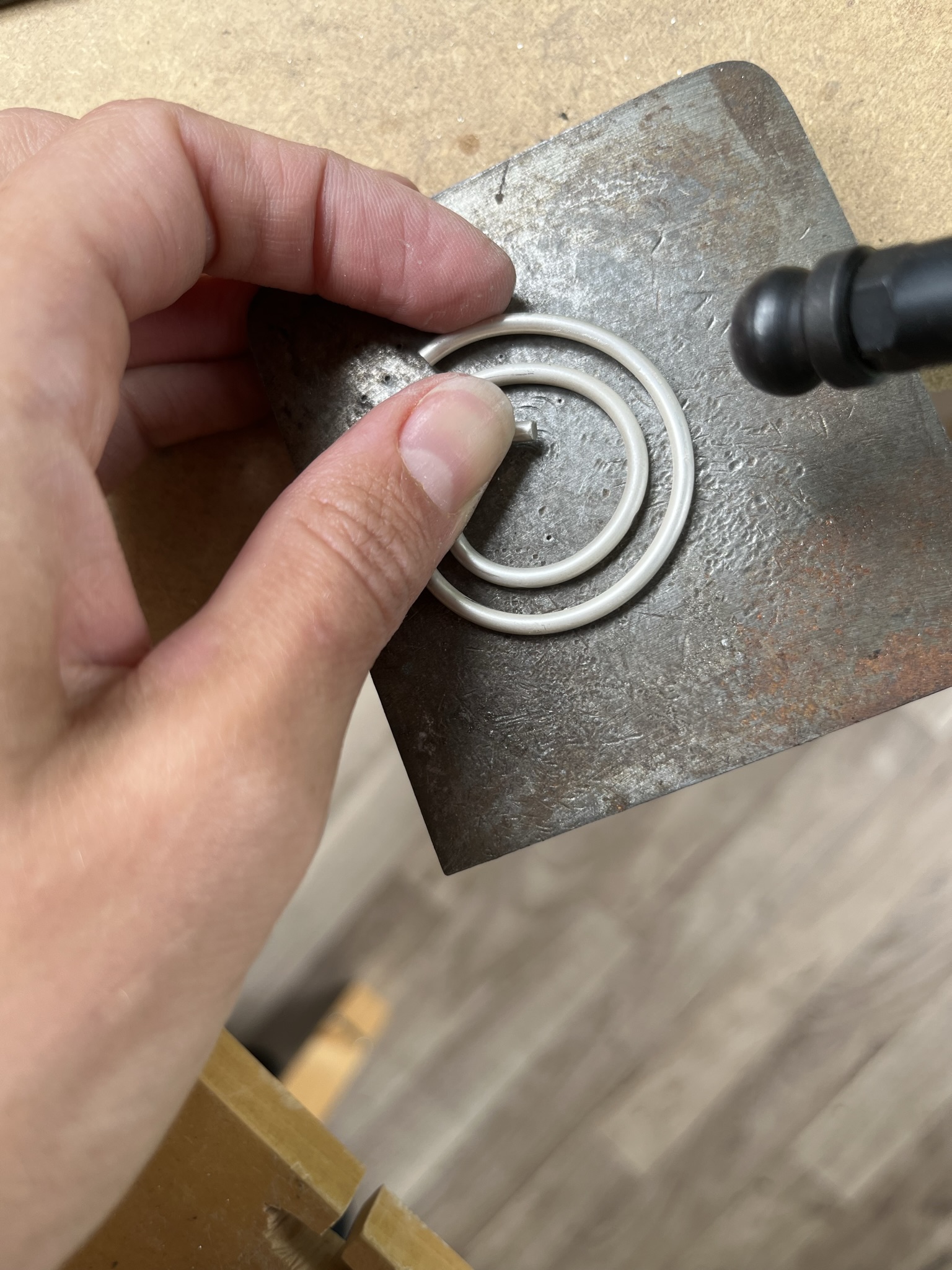 Add texture to silver pendant using a hammer