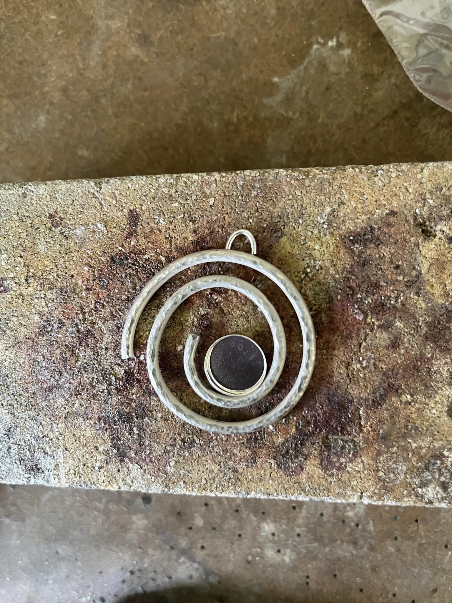 Place the silver pendant on a heatproof block