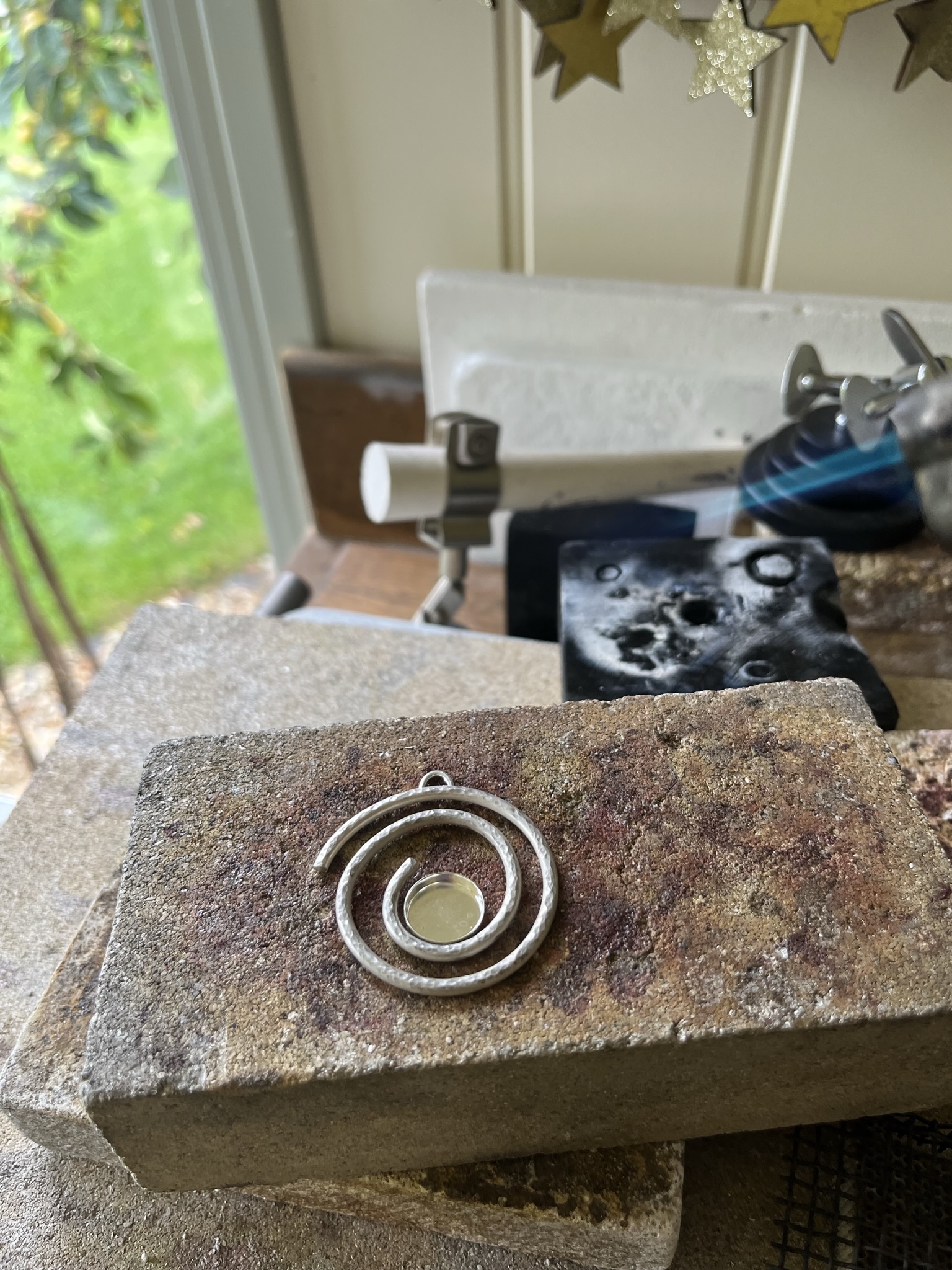 Heat the silver spiral with a blow torch until the solder melts and flows.