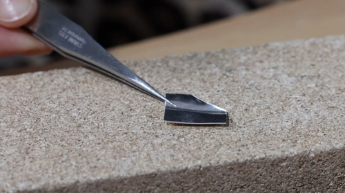 placing silver sheet onto soldering block with tweezers