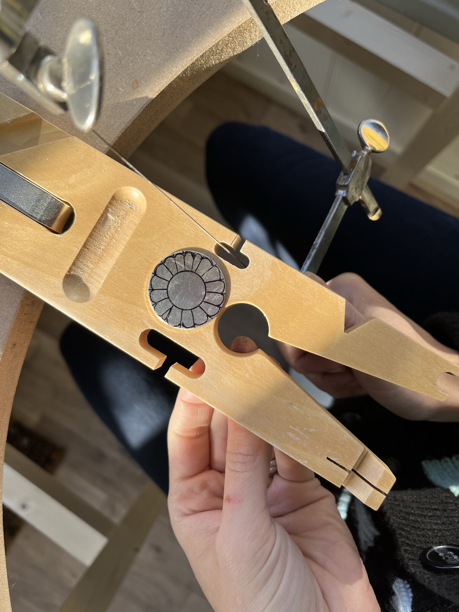 Using a piercing saw to cut along each line on the silver disc. 