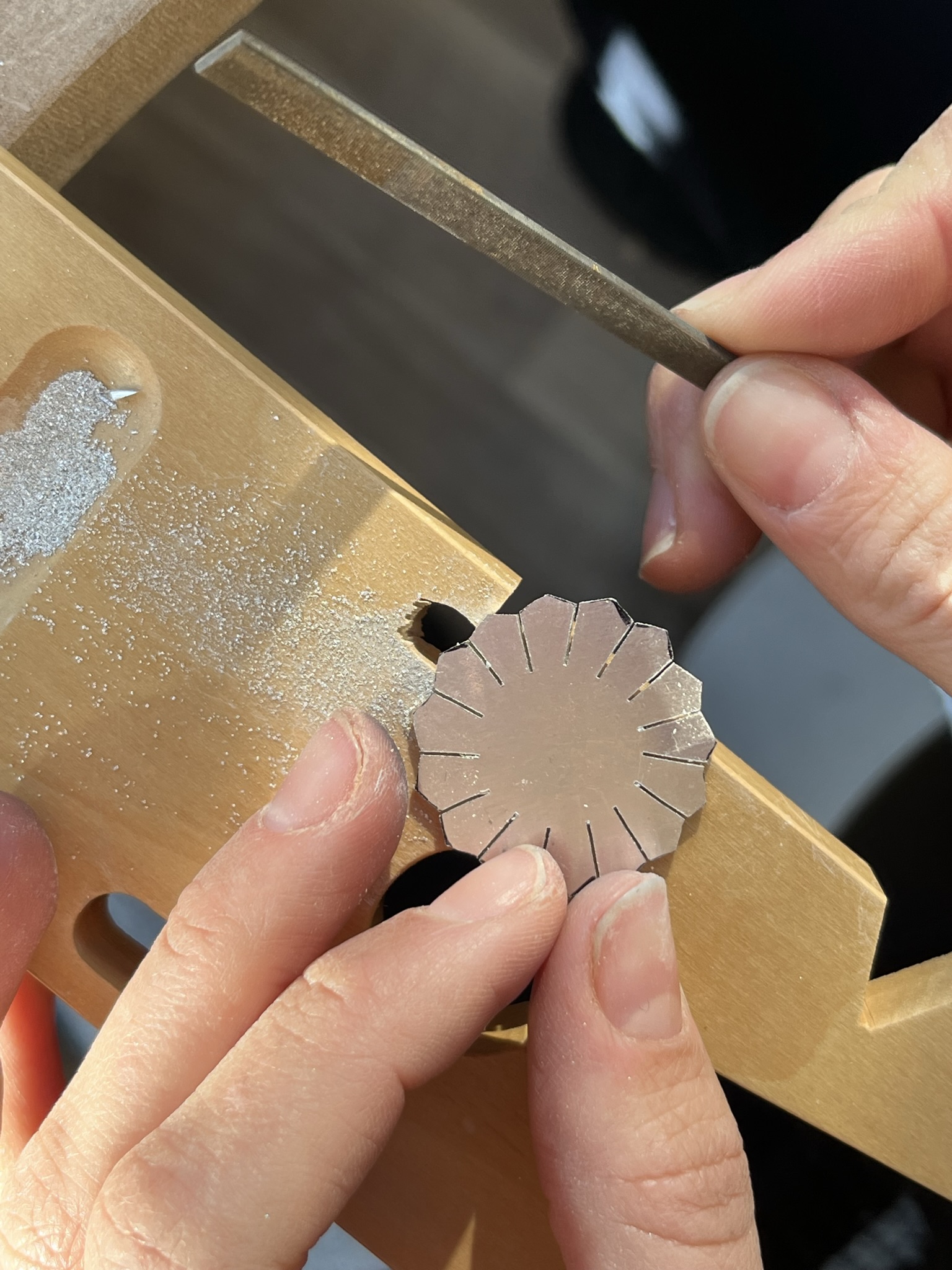 Using a needle file to file away the points of the petals. 