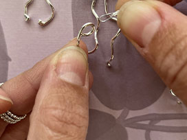 Thread silver squiggles onto a silver chain