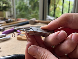 Use round nose pliers to grip and twist the wire