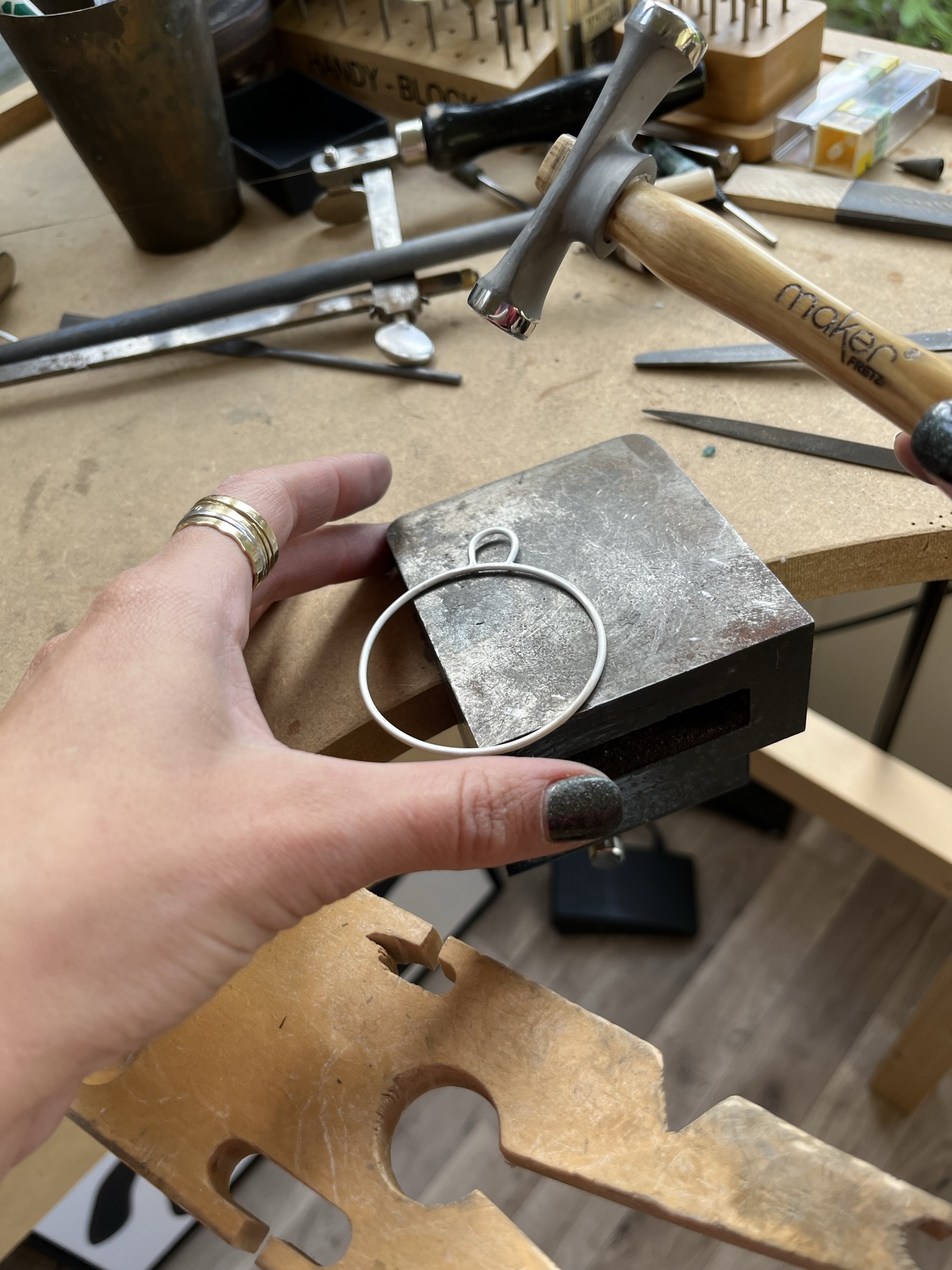 Place the silver bauble shape on a steel block and use a planishing hammer to hit the shape evenly. 