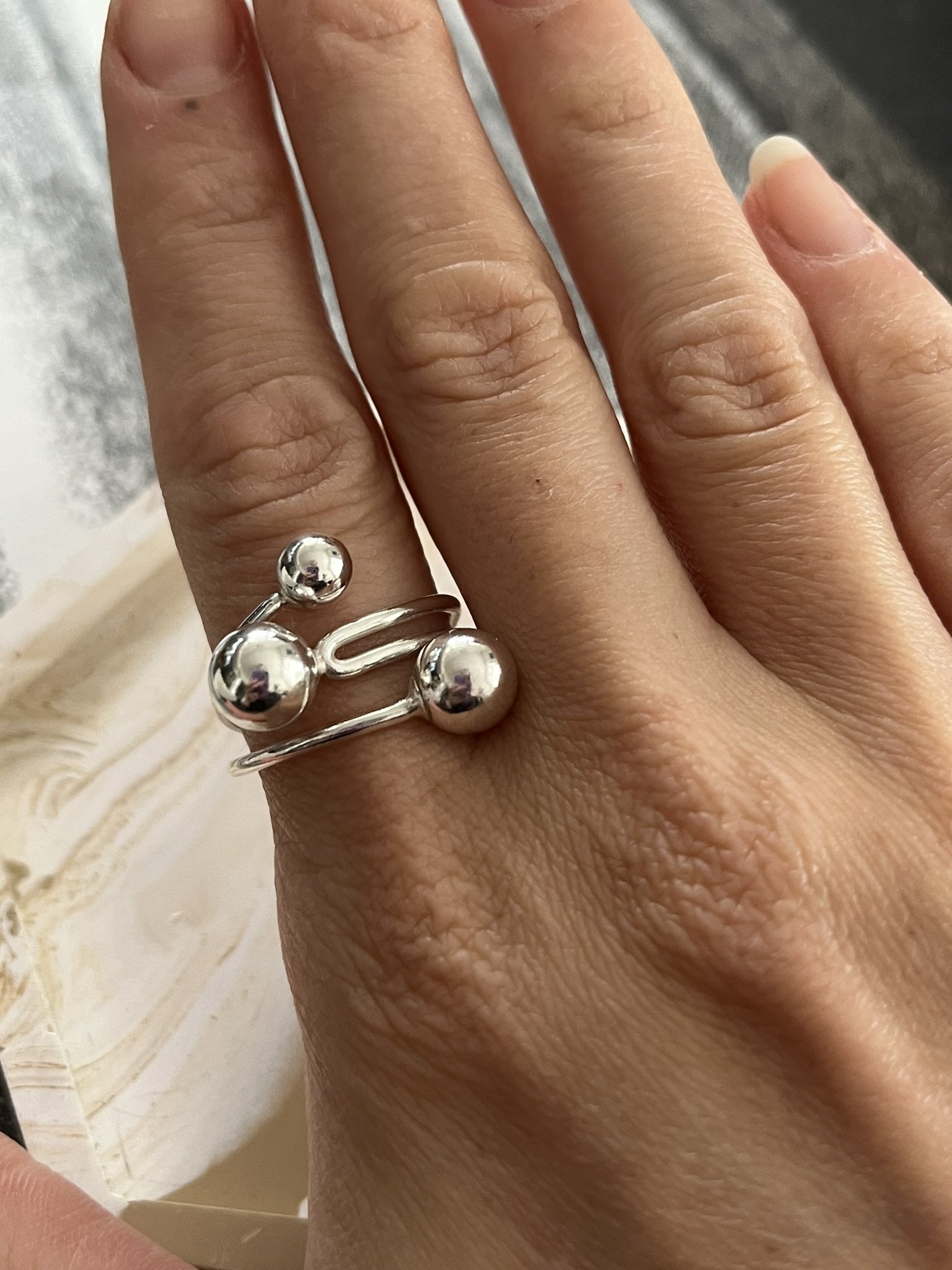 Adjustable ring made from sterling silver one hole beads and round wire.