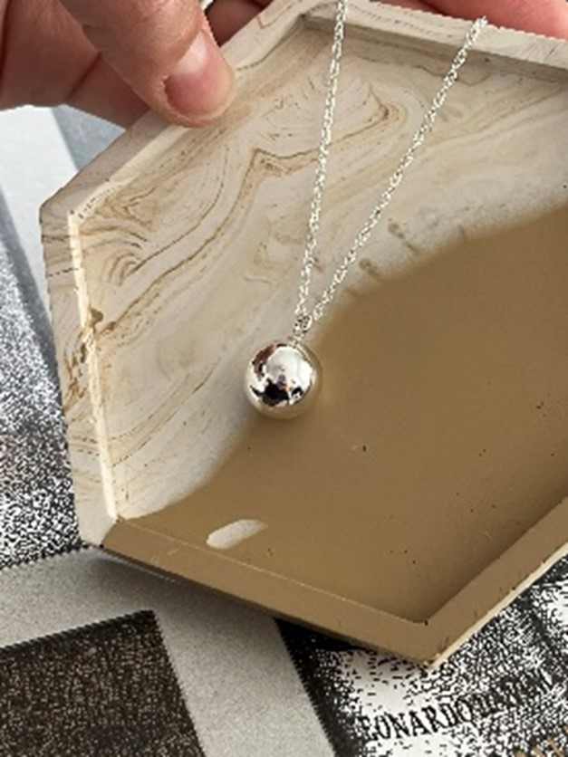 Sterling silver one hole bead threaded on a chain to make a pendant.