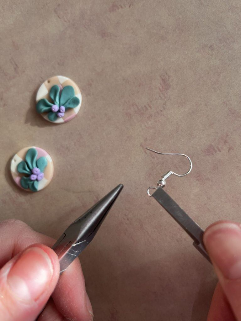 Hoop of a hook wire being gripped by pliers to close the hoop flush.